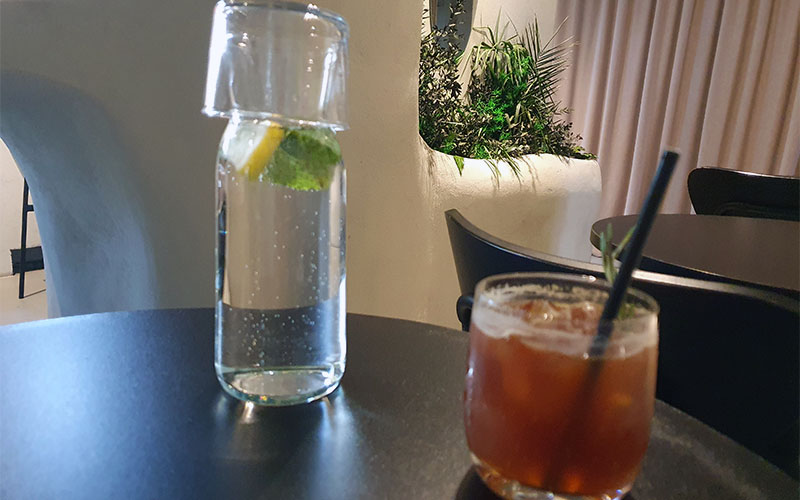 Der Krug mit Wasser und ein Espresso-Tonic