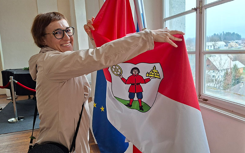 Kaja Beton, Direktorien des Instituts für Tourismus und Kultur in Radovljica zeigt und das Wappen