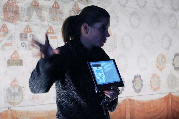 Kastellanin PhDr. Kateřina Rozinková zeigt uns die Erklärung des Wappens am Tablet 